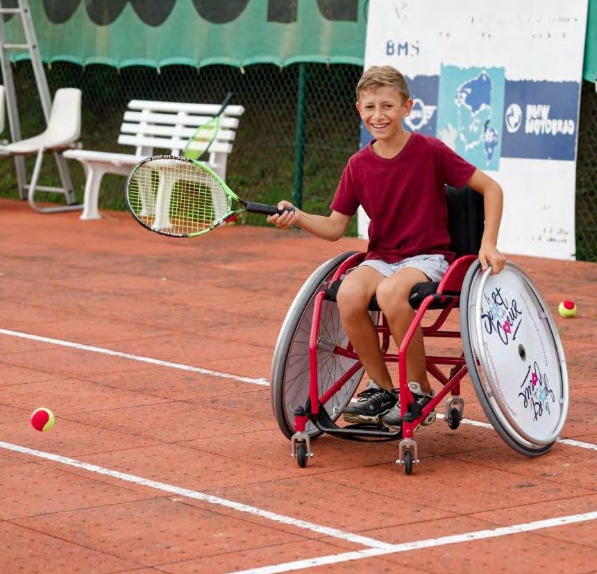 Jeune joueur de tennis en fauteuil multisport équipé d'un tour de roue Le sport a du cœur